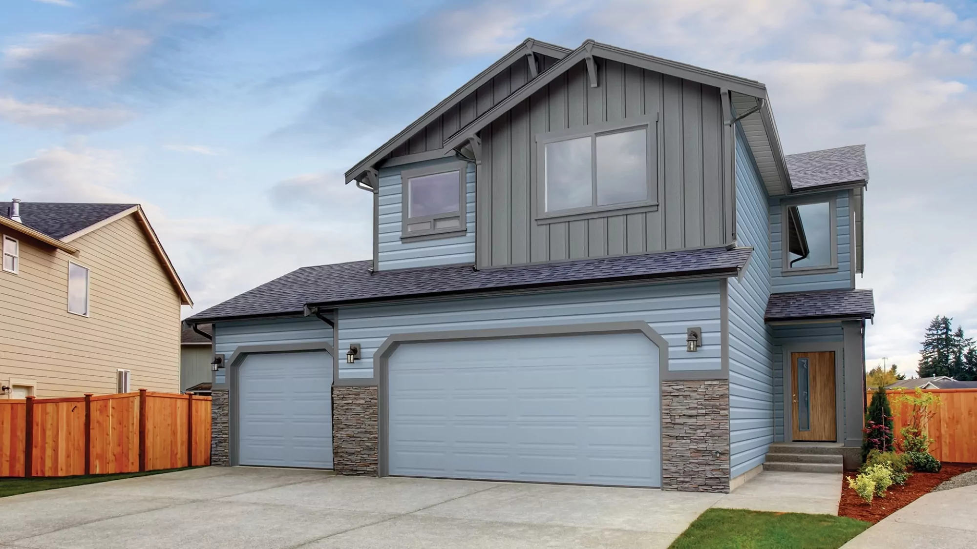Home with durable steel siding and a green metal roof installed by CoMitted Roofing & Exteriors.
